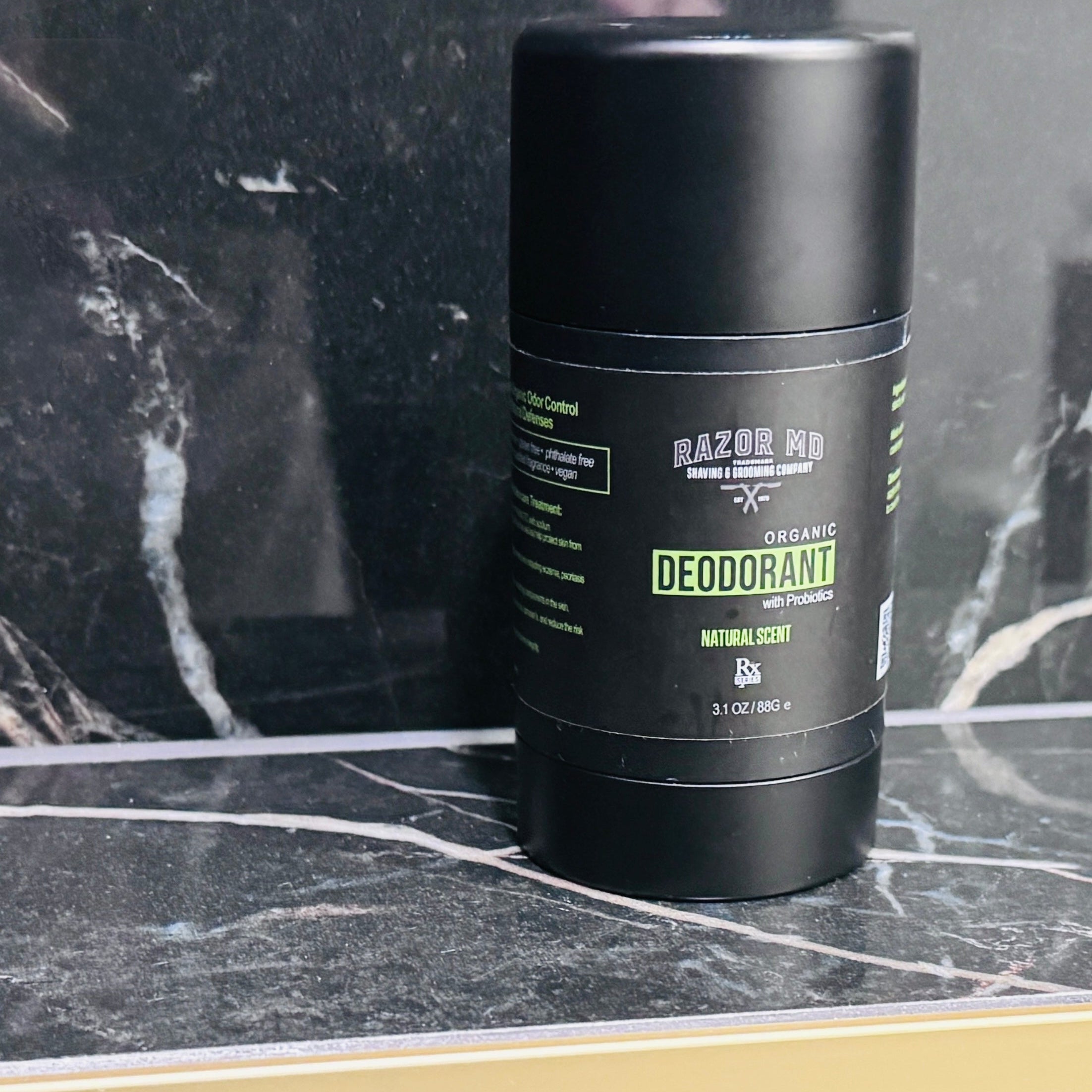 RAZOR MD Black deodorant container on a marble surface