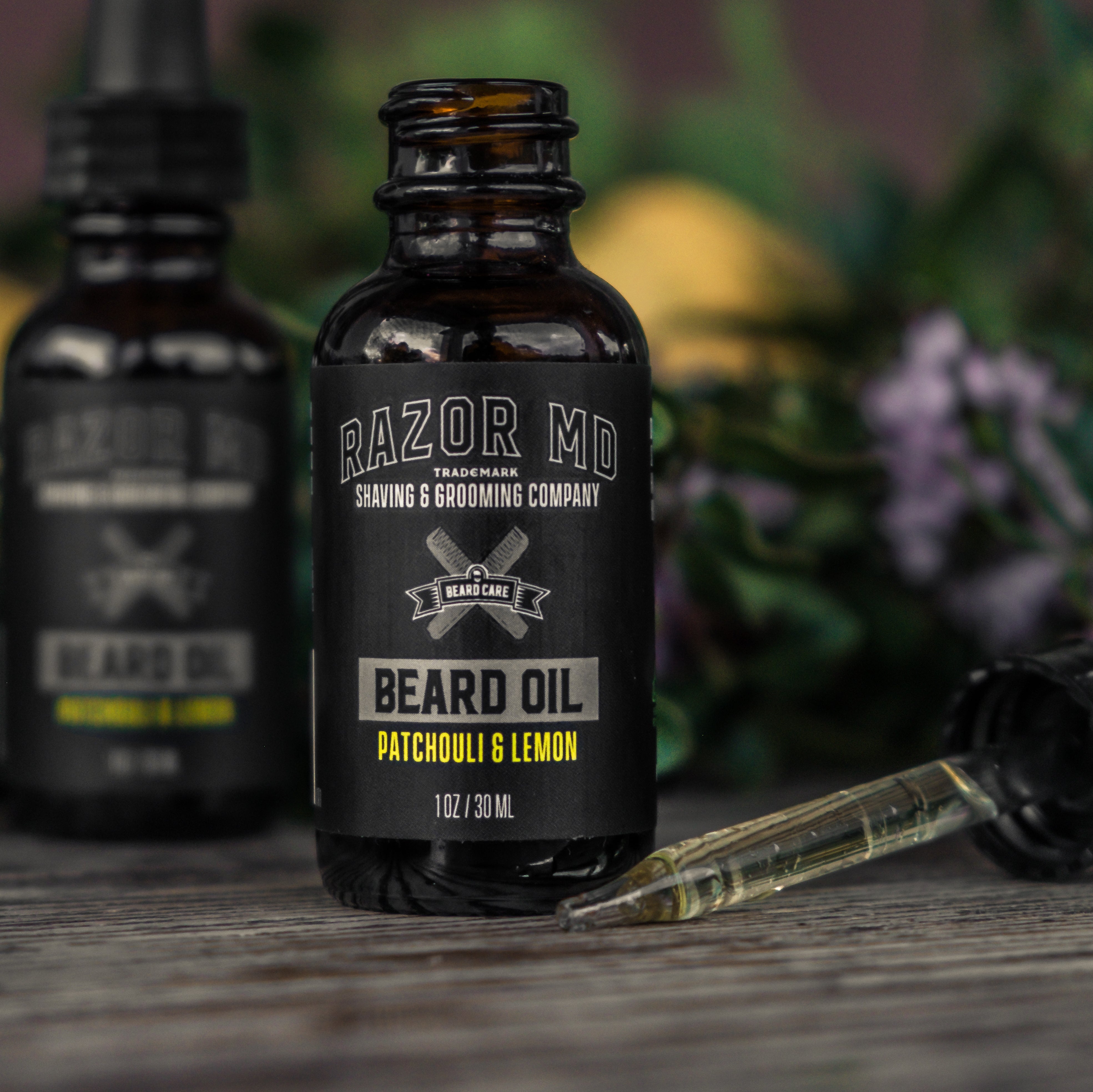 Bottle of RAZOR MD beard oil on a wooden surface with flowers in the background