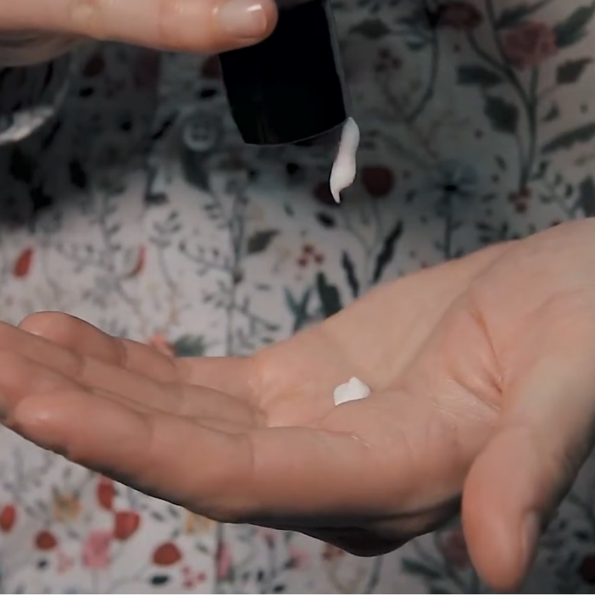 Person holding a RAZOR MD Post Shave Lotion in their hand with a neutral background