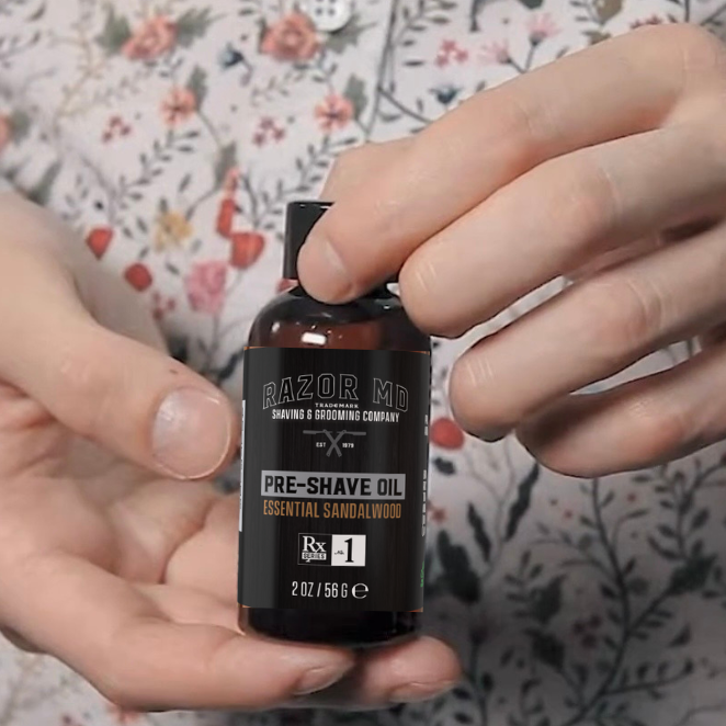 Person holding a small RAZOR MD Pre-shave Oil