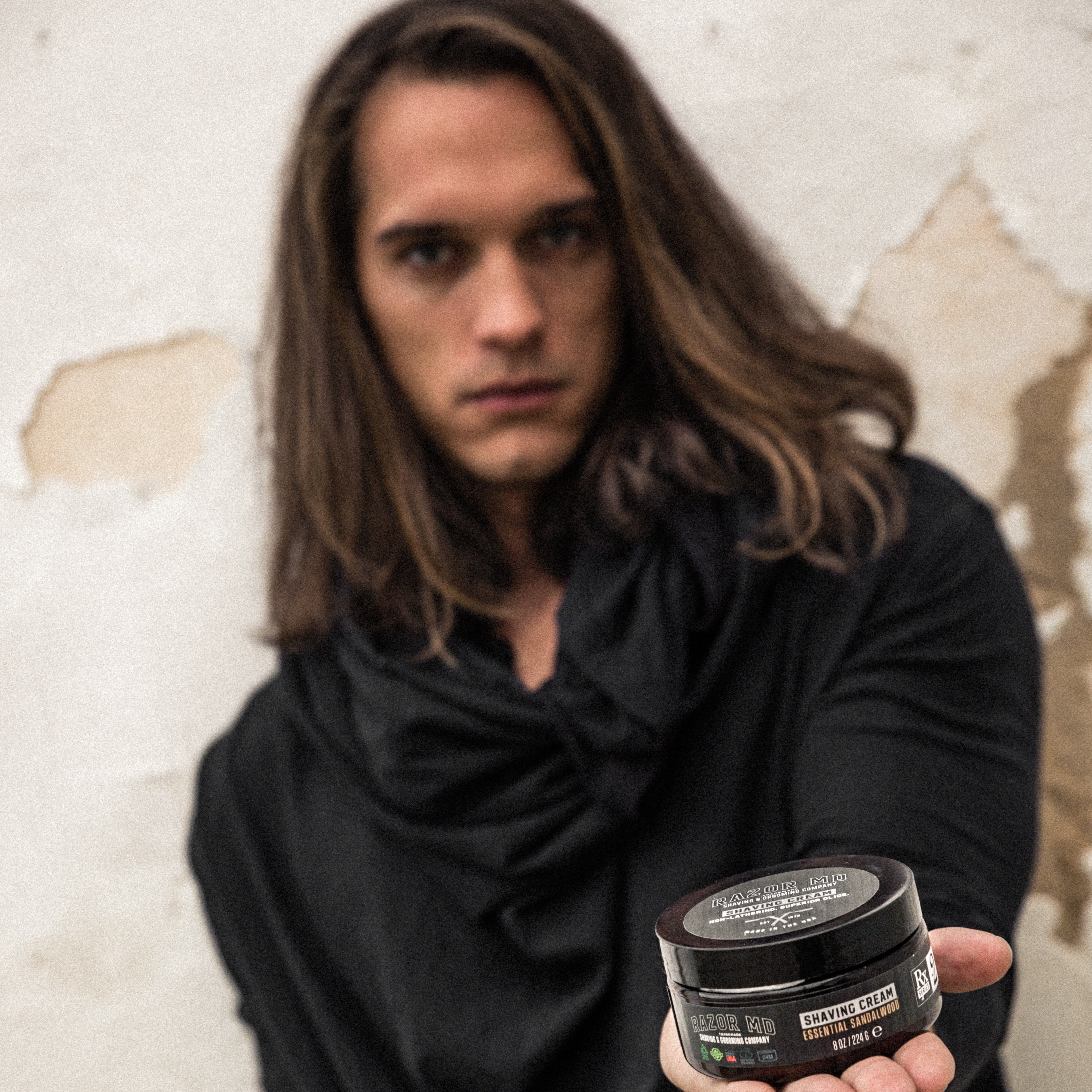 Man holding a RAZOR MD Shave Cream jar 