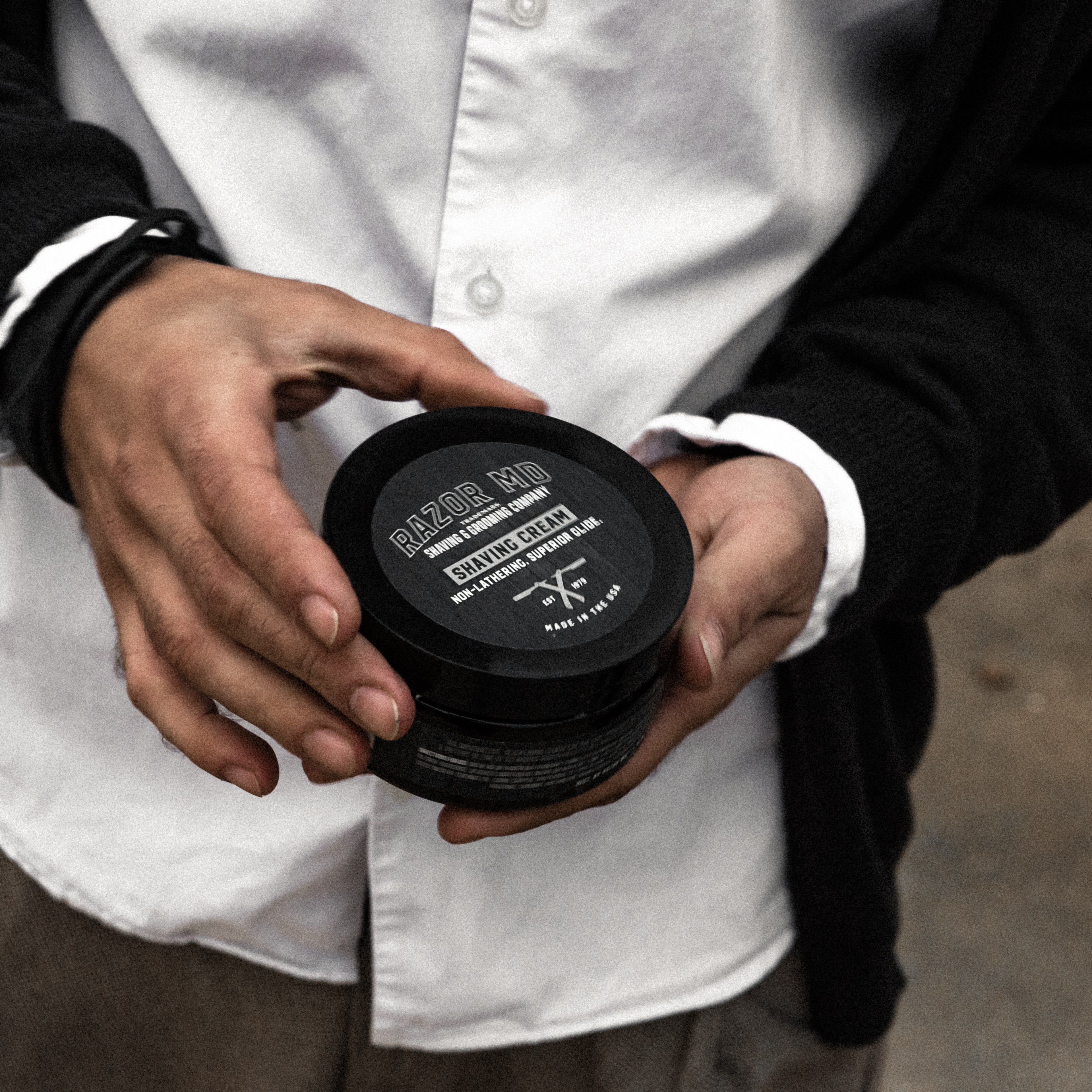 Person holding a RAZOR MD Shave Cream jar