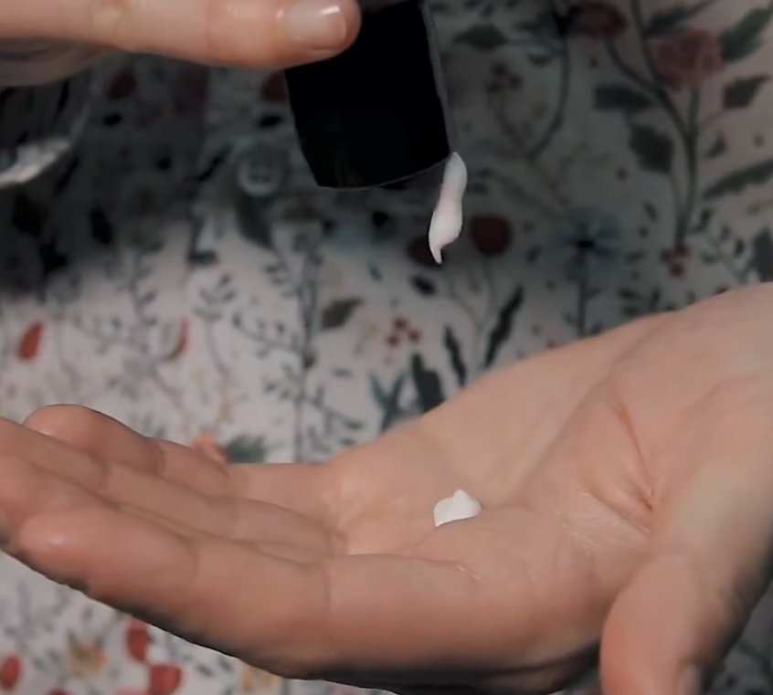 Person holding a RAZOR MD Post Shave Lotion in their hand with a neutral background